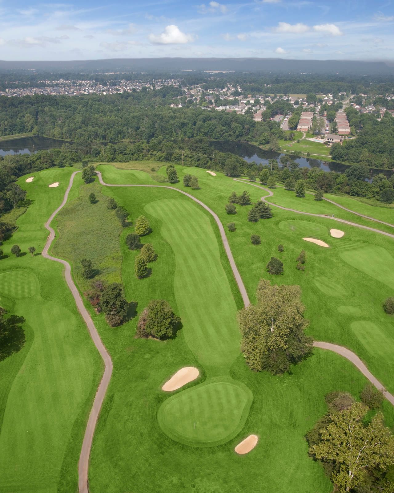 Aerial view of tree-lined fairways and bunkered greens at Quail Chase