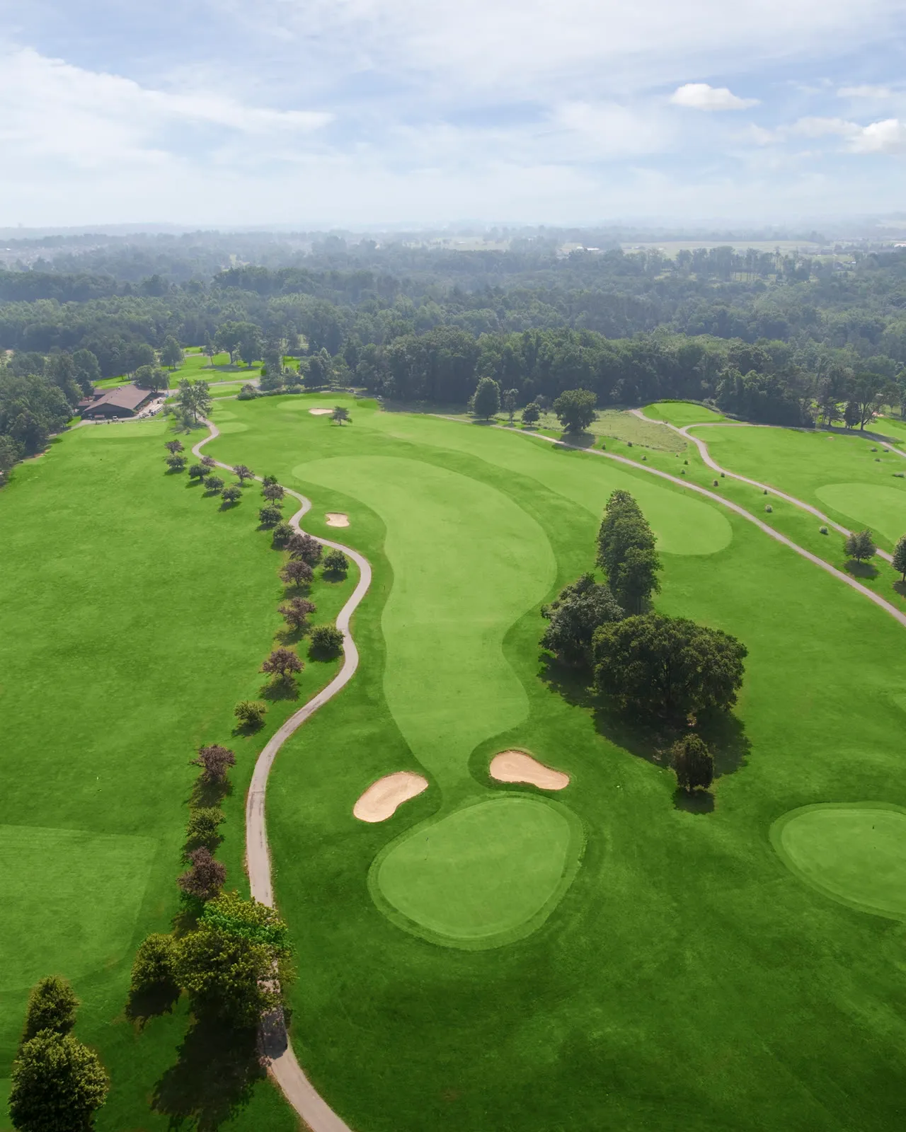 Aerial view of Quail Chase greens and bunkers with a lake in the distance