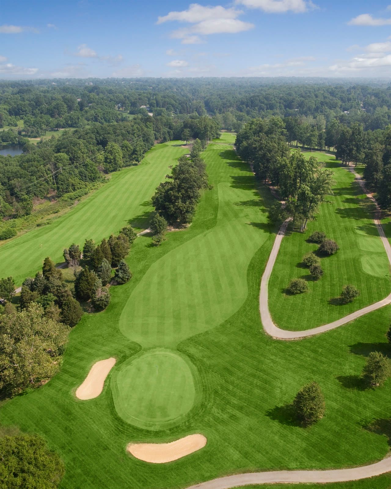 Aerial view of a fairway leading to a bunkered green at Quail Chase