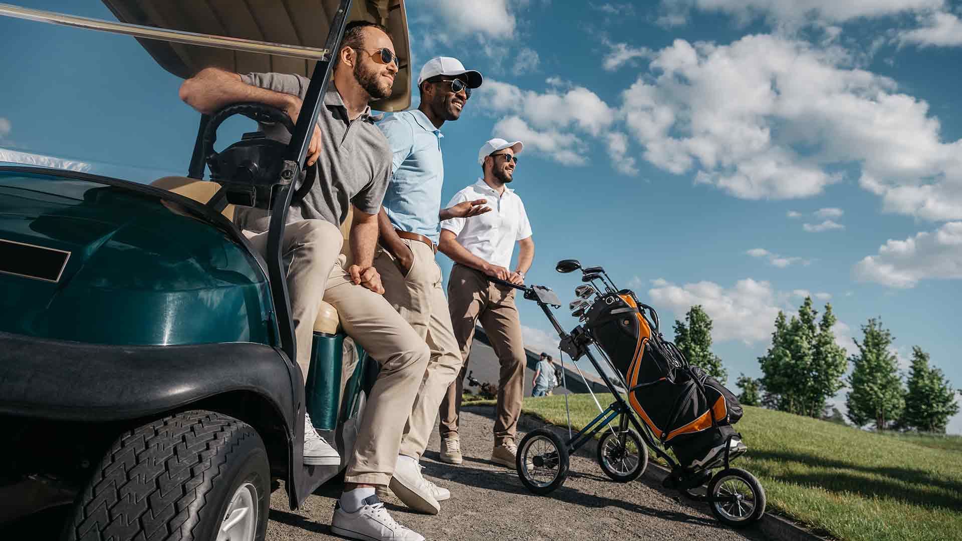 Golfers gathered beside a golf cart